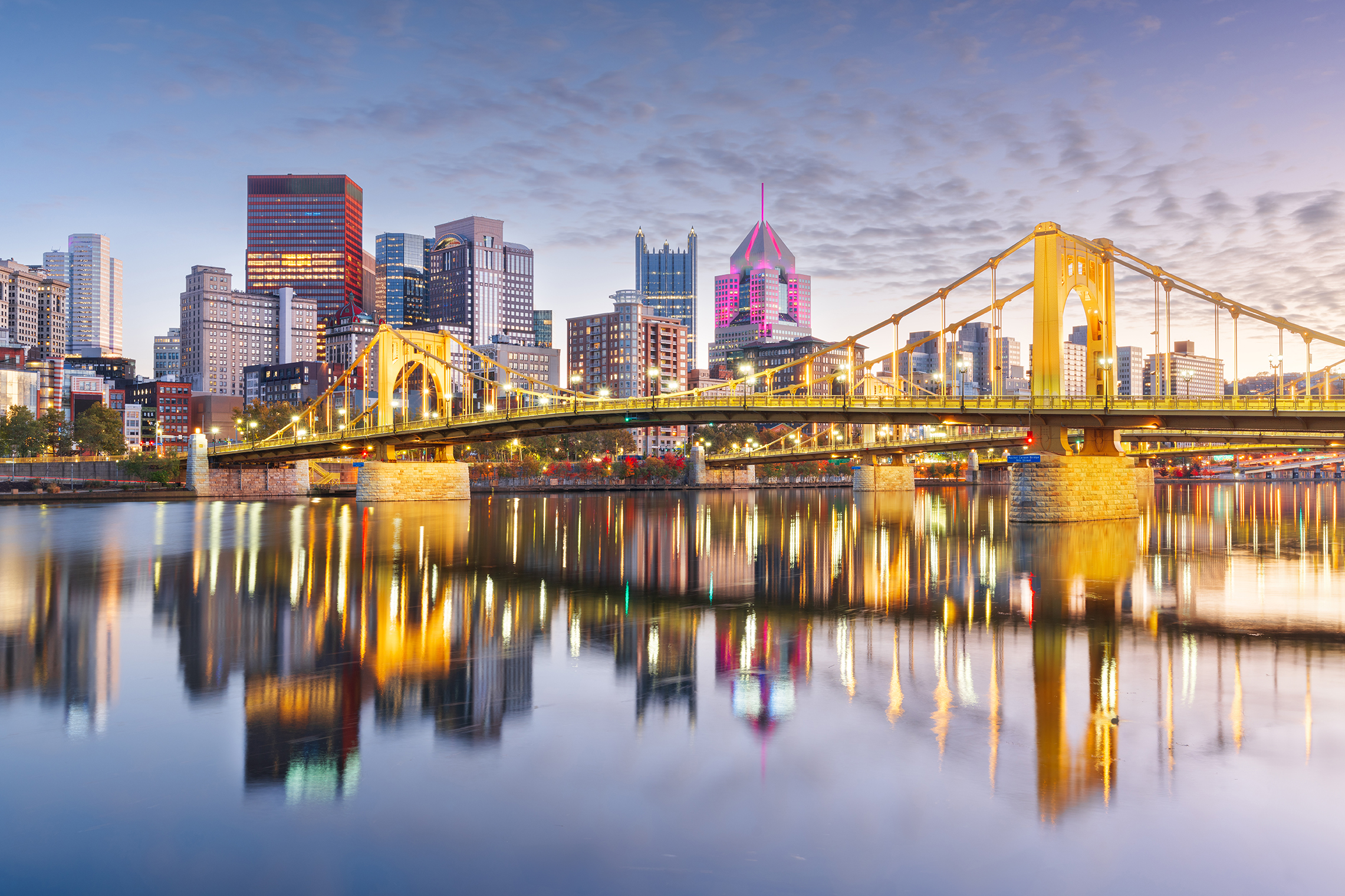 Pittsburgh skyline and a river bridge at dusk